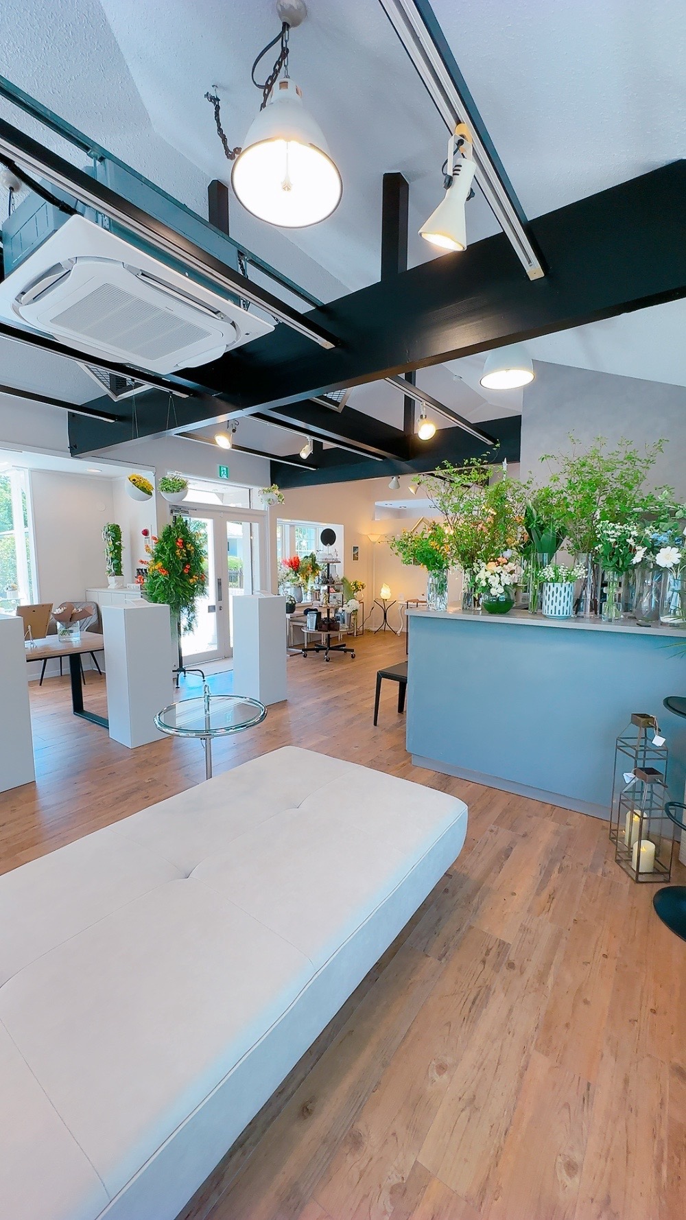 光が差し込むアトリエ伊豆プラスの店内と季節の花